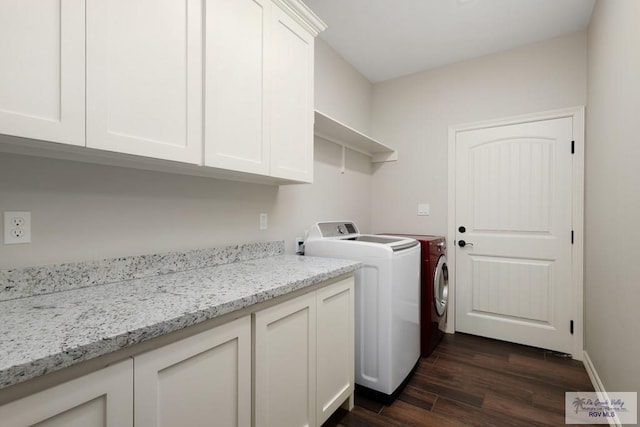 clothes washing area featuring washing machine and dryer, dark hardwood / wood-style flooring, and cabinets