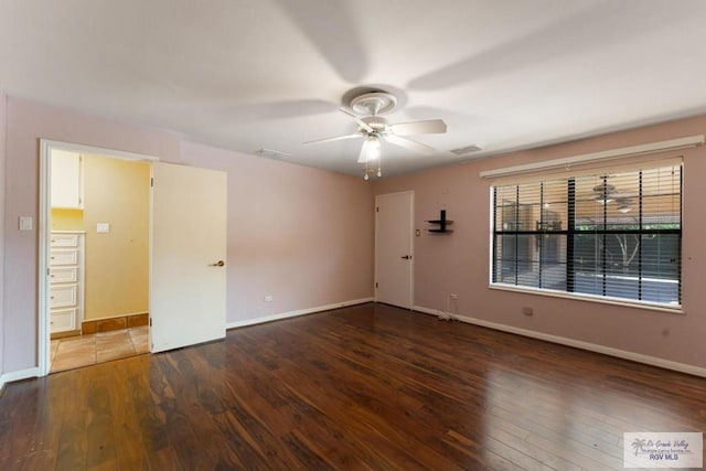 spare room featuring dark wood-type flooring and ceiling fan