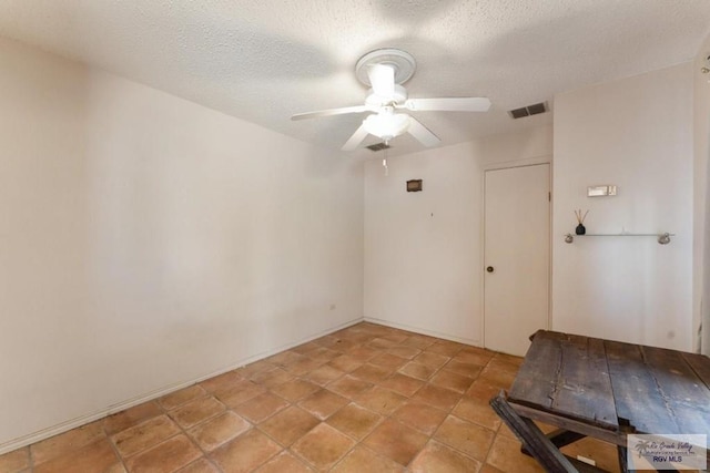 empty room featuring a textured ceiling and ceiling fan