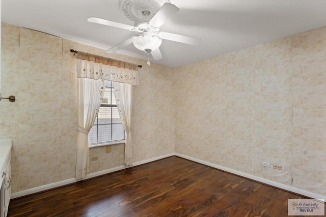 spare room with ceiling fan and dark hardwood / wood-style flooring