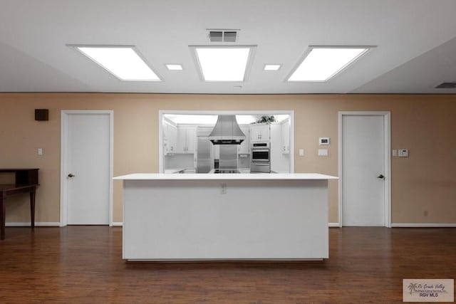 kitchen featuring a breakfast bar area, stainless steel appliances, white cabinets, and a kitchen island