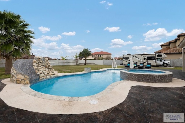 view of pool with a pool with connected hot tub, fence, and a lawn