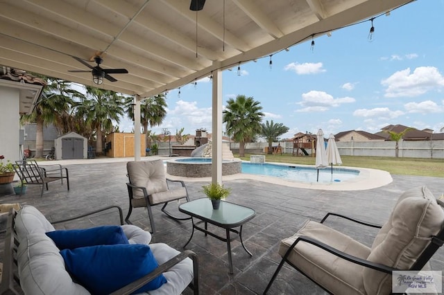 view of patio / terrace with ceiling fan, an outdoor hangout area, an in ground hot tub, an outbuilding, and a shed