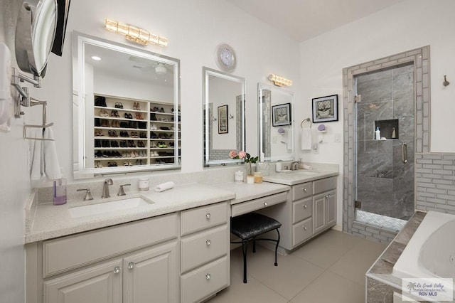 full bathroom featuring a stall shower, tile patterned flooring, vanity, and a bath