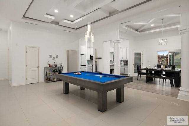 recreation room with coffered ceiling, decorative columns, and a towering ceiling