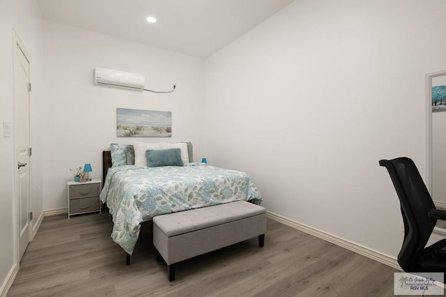 bedroom featuring recessed lighting, a wall unit AC, light wood-style flooring, and baseboards