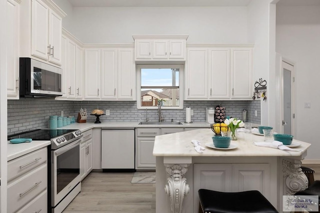 kitchen featuring a sink, white dishwasher, stainless steel electric stove, light countertops, and backsplash