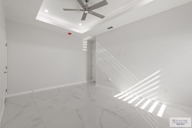 unfurnished room featuring a tray ceiling and ceiling fan