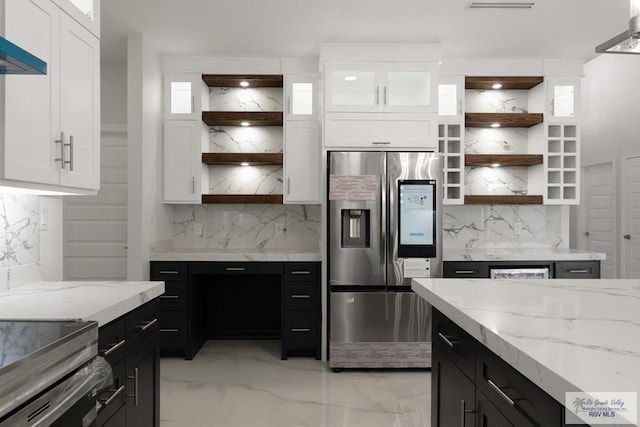 kitchen featuring white cabinetry, ventilation hood, stainless steel fridge with ice dispenser, and backsplash