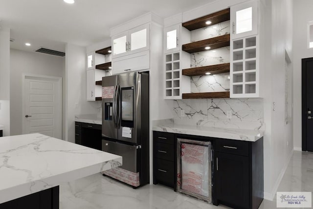 kitchen with white cabinetry, wine cooler, stainless steel fridge, decorative backsplash, and light stone countertops