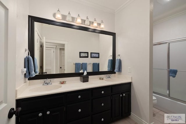 1808 E Palm Valley Dr, Harlingen, TX 78552 - bathroom featuring tile patterned floors, crown molding, double vanity, toilet, and bath / shower combo with glass door