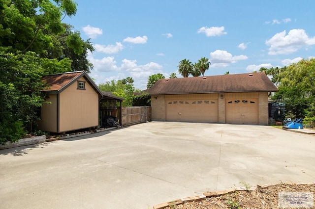 1808 E Palm Valley Dr, Harlingen, TX 78552 - view of home's exterior featuring a detached garage, brick siding, fence, and an outdoor structure