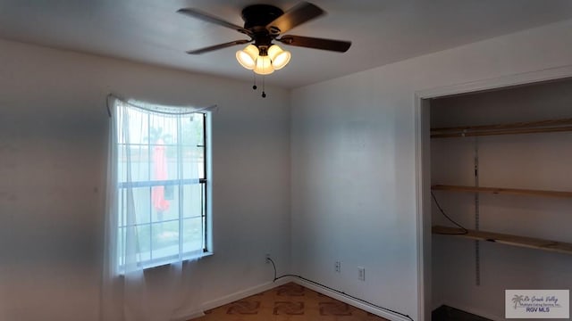 unfurnished bedroom with ceiling fan, multiple windows, and a closet