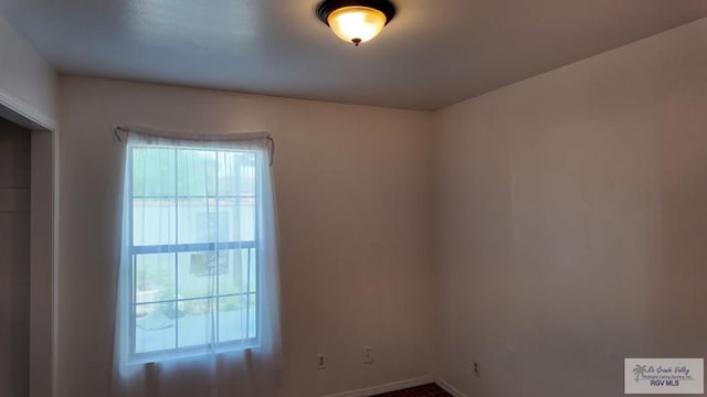 unfurnished room featuring baseboards