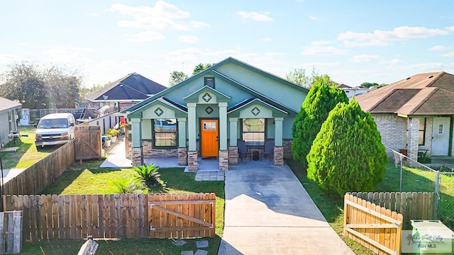 bungalow-style home with driveway, stone siding, a gate, a front lawn, and a fenced front yard
