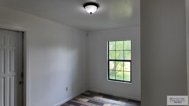 unfurnished room with wood finished floors and baseboards