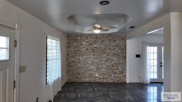entrance foyer featuring a raised ceiling, visible vents, a ceiling fan, and marble finish floor