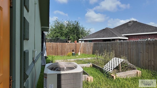 view of yard featuring cooling unit, a vegetable garden, and a fenced backyard