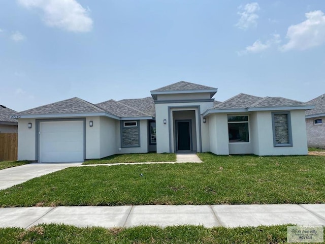 view of front of property with a garage and a front lawn