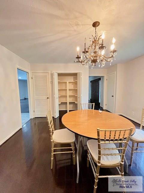 dining area with a chandelier and dark hardwood / wood-style floors