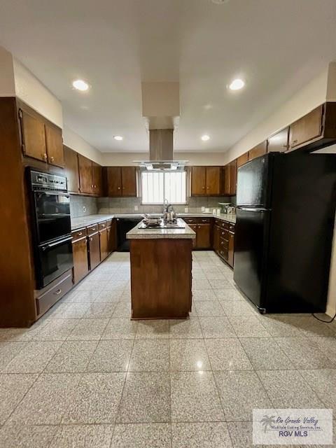 kitchen with decorative backsplash, dark brown cabinets, island range hood, black appliances, and a kitchen island