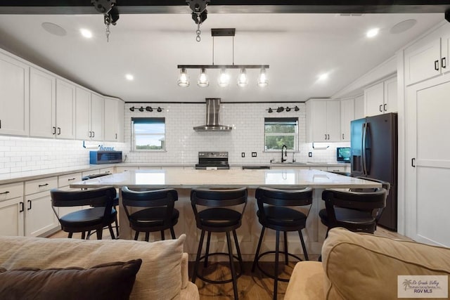 500 Parker Cir # 21, La Feria, TX 78559 - kitchen with black refrigerator with ice dispenser, stainless steel range with electric cooktop, a sink, wall chimney exhaust hood, and tasteful backsplash