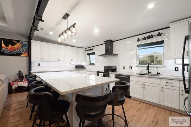 500 Parker Cir # 21, La Feria, TX 78559 - kitchen featuring wall chimney exhaust hood, a sink, black appliances, decorative backsplash, and light wood finished floors