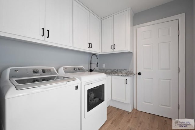 500 Parker Cir # 21, La Feria, TX 78559 - washroom featuring washer and dryer, light wood-type flooring, and cabinet space