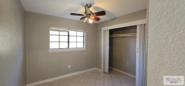 unfurnished bedroom with ceiling fan, a closet, and light tile patterned floors