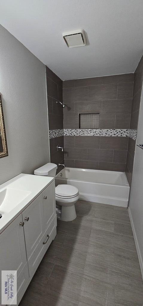 full bathroom featuring vanity, toilet, and tiled shower / bath