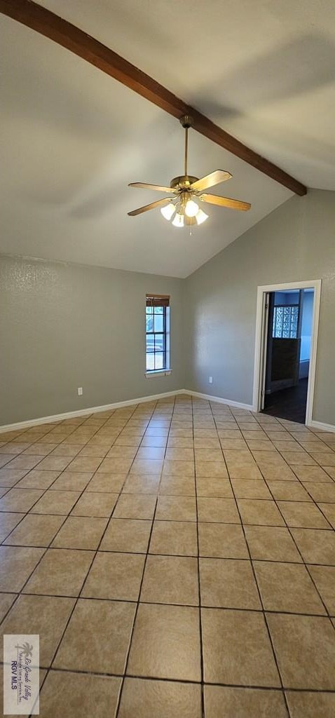 tiled empty room with ceiling fan and lofted ceiling with beams