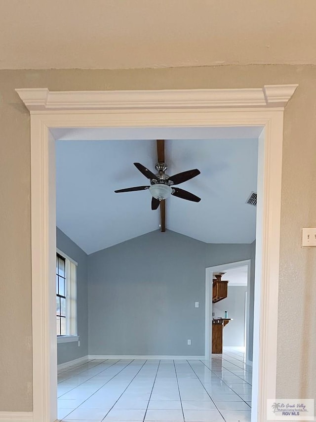 tiled spare room featuring vaulted ceiling and ceiling fan