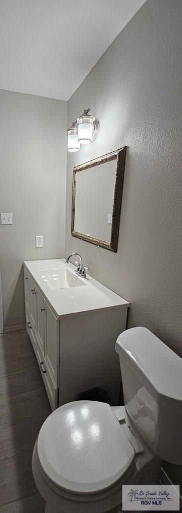 bathroom featuring hardwood / wood-style floors, vanity, and toilet