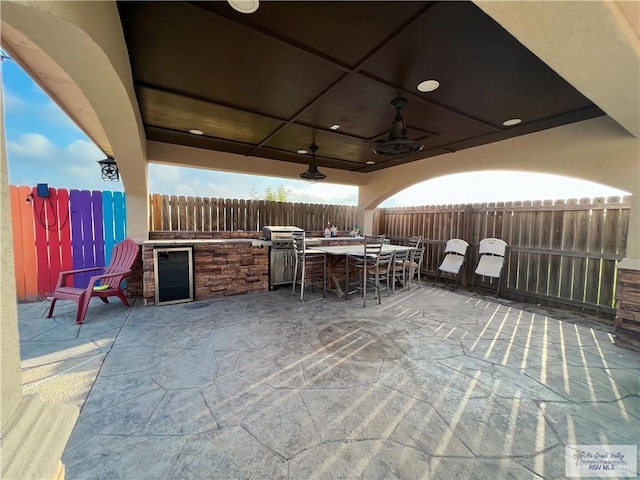 view of patio / terrace with an outdoor kitchen, ceiling fan, area for grilling, and beverage cooler