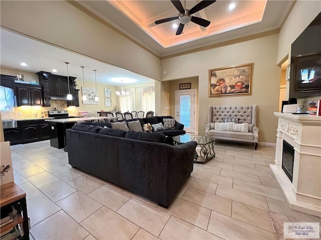 living room with a wealth of natural light, light tile patterned flooring, and ceiling fan with notable chandelier