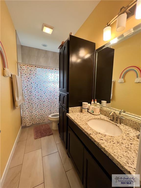 bathroom featuring tile patterned flooring, vanity, and toilet