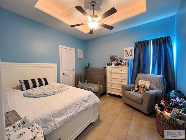 bedroom with a raised ceiling and ceiling fan