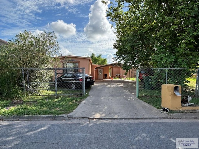 view of front facade featuring fence, driveway, and stucco siding