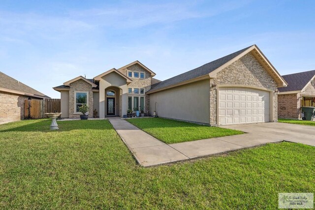 1510 Karis Ct, Harlingen, TX 78550 - view of front of home featuring concrete driveway, stucco siding, a garage, and stone siding