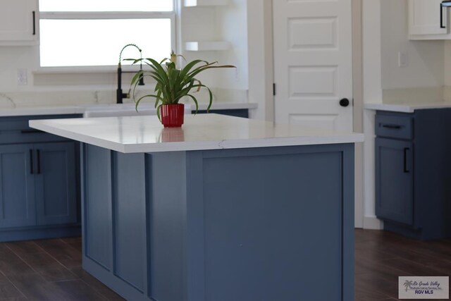 1272 Bridle Way, San Benito, TX 78586 - kitchen with blue cabinets, dark wood-style floors, a center island, and white cabinetry