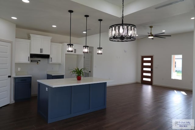 1272 Bridle Way, San Benito, TX 78586 - kitchen with under cabinet range hood, dark wood-style floors, a ceiling fan, white cabinetry, and a center island