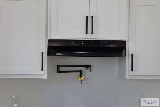 1272 Bridle Way, San Benito, TX 78586 - kitchen view of extractor fan, white cabinets, and pot filler