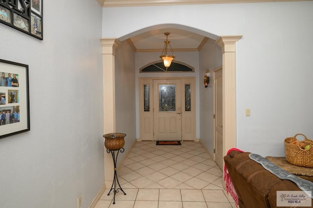 tiled entrance foyer with crown molding and decorative columns