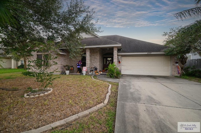 ranch-style home featuring a yard and a garage