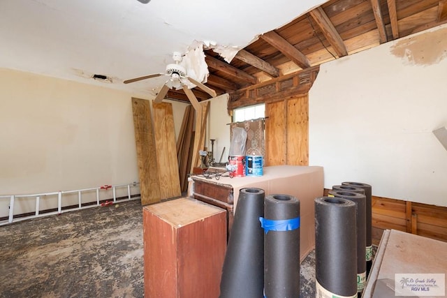 interior space featuring ceiling fan and wooden walls