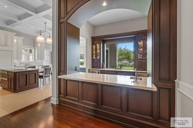 bathroom with tasteful backsplash, beam ceiling, coffered ceiling, and hardwood / wood-style flooring