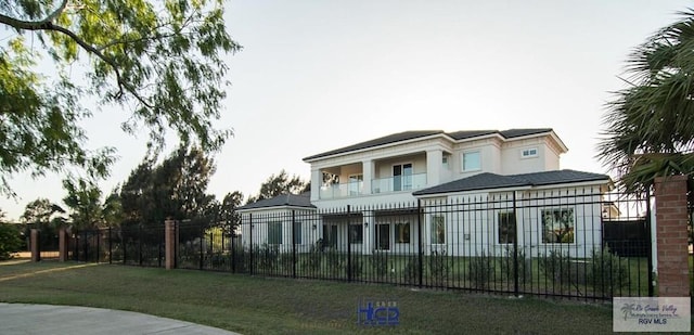 view of front of home featuring a front yard and a balcony