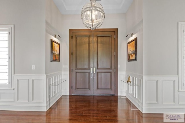 foyer entrance featuring dark hardwood / wood-style floors and an inviting chandelier