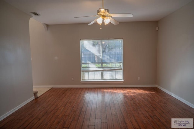 spare room with ceiling fan and dark wood-type flooring