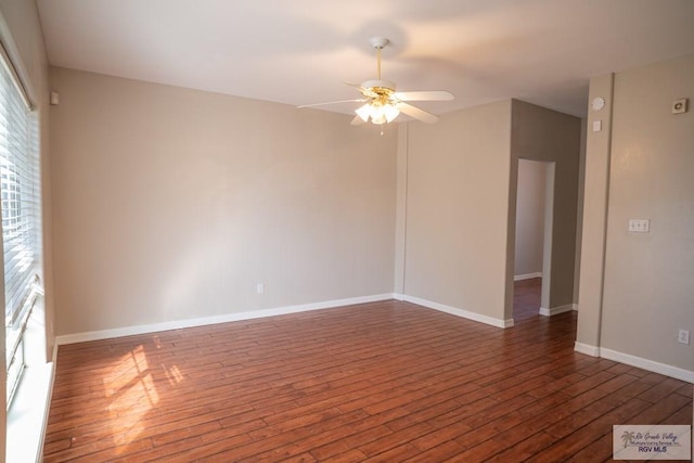 unfurnished room with ceiling fan and dark wood-type flooring